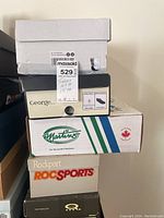 Stack of white, George, Martin’s, Rockport and SoulCal Q shoe boxes
