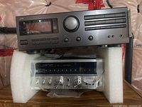 JVC and Sansui receivers stacked on foam packaging