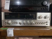 Front view of receiver showing silver faceplate, knobs and wood veneer case.