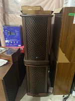 Two stacked Sansui SF-2 2-way speakers with wooden lattice front grills and dark brown finish in storage area.