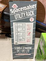 Photo of the Spacemaker Utility Rack box showing brand, product name, and its dimensions 58x30x12 inches.