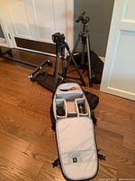 Overview showing two tripods, carry case, open camera bag with lenses