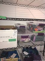 Five clear plastic containers and one cardboard box on a shelf holding various quilting fabric pieces and remnants.