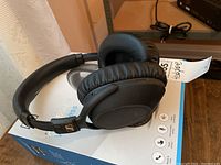 Full view of Sennheiser PXC-550-11 wireless over-ear headphones resting on box, showing padded ear cups and headband.