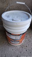 Full view of white plastic bucket with label and handle