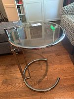 Front and top view showing the clear glass top and chrome metal frame with semi-circular base and vertical support bar.