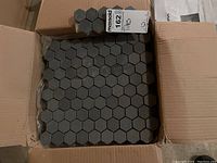 Top view of box showing basalt hexagon mosaic tile sheets on mesh backing