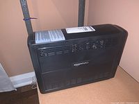Side view of the black UPS unit with Amazon Basics logo visible, showing air ventilation slots