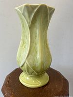 Front and side profile view of Early McCoy Lotus Leaf Vase in blended green glaze on wooden surface against white background