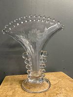 Front angle of clear glass vase showing etched cornflower design and glass bead edge.