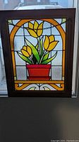 Front view of wooden framed stained glass window panel showing full tulip floral design with yellow flowers and red flower pot.