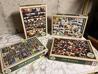 All four Cobble Hill puzzle boxes grouped showing box cover images of quilts, chocolates, postcards, and Hardy Boys