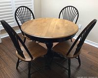 Assembled round table with four chairs on hardwood floor