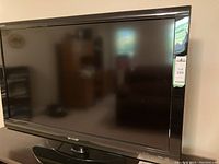 Front view of Sharp Aquos 40-inch flat screen TV with seller's lot tag.