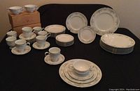 Full set of Noritake Ireland Limerick dinnerware including plates, soup bowls, teacups and saucers arranged on table with boxed soup bowls visible.