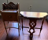 Photo showing the pair of small antique wood tables side by side on a wood floor.