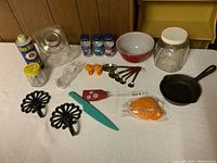 Wide view of all kitchen items including Pyrex bowl, cast iron pan, and various utensils and jars