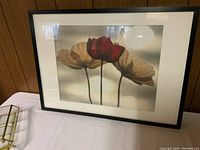 Framed photographic artwork of three poppies placed on white surface showing the full piece.
