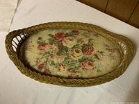 Top view of the oval vintage wicker tray showing braided rim and floral print on the tray interior.