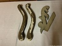 Photo of the three vintage wood pieces arranged on a white surface, showing the worn paint and shapes.