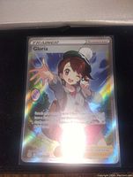 Full art holo foil Gloria Pokemon Trainer card with vibrant rainbow holographic finish.