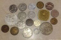 Top-down photo showing all coins arranged on a flat surface, displaying various sizes and designs including national symbols and historical figures.