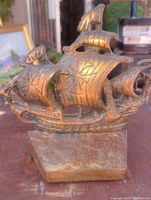 Photo showing detailed view of cast iron May Flower ship book end with aged copper patina and textured sails