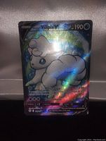 Close-up photo of the Alolan Vulpix V full art holo foil Pokemon card showing front details including artwork, holo effect, HP, and attack moves.