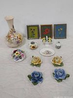 Full lot image showing Royal Worcester vase, oil paintings, and various porcelain flower decorations