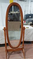 Front view of the full-length oval cheval mirror showing the wood frame and beveled glass.