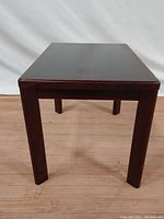 Front view of dark rosewood rectangular side table with tapered legs