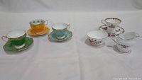 Full display of all tea cups, saucers, sugar bowl, and creamer on white background