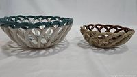 Side view of two ceramic open lattice bowls showing size and color differences