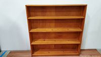 Front view of the solid wood 4 shelf bookcase showing natural wood grain and knots.