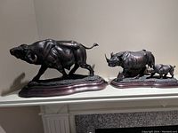 Both resin animal sculptures displayed side by side on a shelf, showing the full figures and bases.