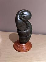 Front view of stone sculpture mounted on wooden base