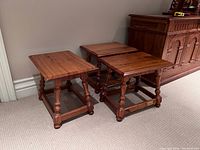Three matching wooden stools arranged in a row plus side view of nearby cabinet