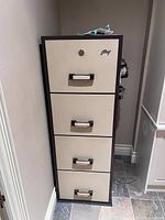 Front view of Godrej fire proof filing cabinet showing all four drawers and the lock on the top drawer with key inserted.