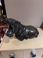 Front right side view of hippo sculpture showing open mouth and body profile