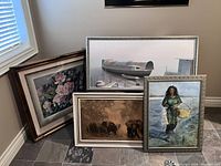 Photo showing all four framed paintings and prints grouped together on the floor leaning against wall.