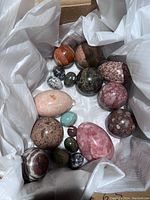 Overhead view of all polished eggs and spheres in box, showing full lot of 15 pieces