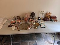 Wide view of all items on folding table showing arrangement and detail of assorted world decor pieces.