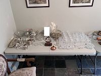 Overall view of the lot showing crystal glassware and silver plate items arranged on table