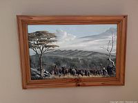 Frontal view of the framed painting showing the shepherd with cattle and an African landscape.