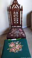 Full view of the antique woodframe prayer chair with brown petit point floral seat and the green petit point cushion footstool stacked in front.