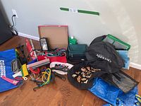 Overview of automotive essentials including bags, tools, flashlights and accessories spread on floor