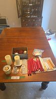 Full view of lot contents including candles and candle holders arranged on a table