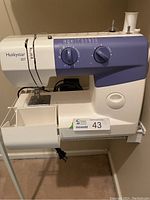Front side view of Husky Star 207 sewing machine showing the machine body, needle area, and branding on the side.