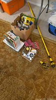 Wide view photo showing boxes of various light bulbs, kits, and a yellow telescoping pole for changing bulbs.