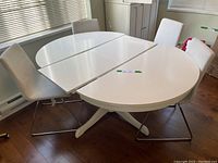 White table in half-extended configuration showing two fixed halves and inserted central leaf.